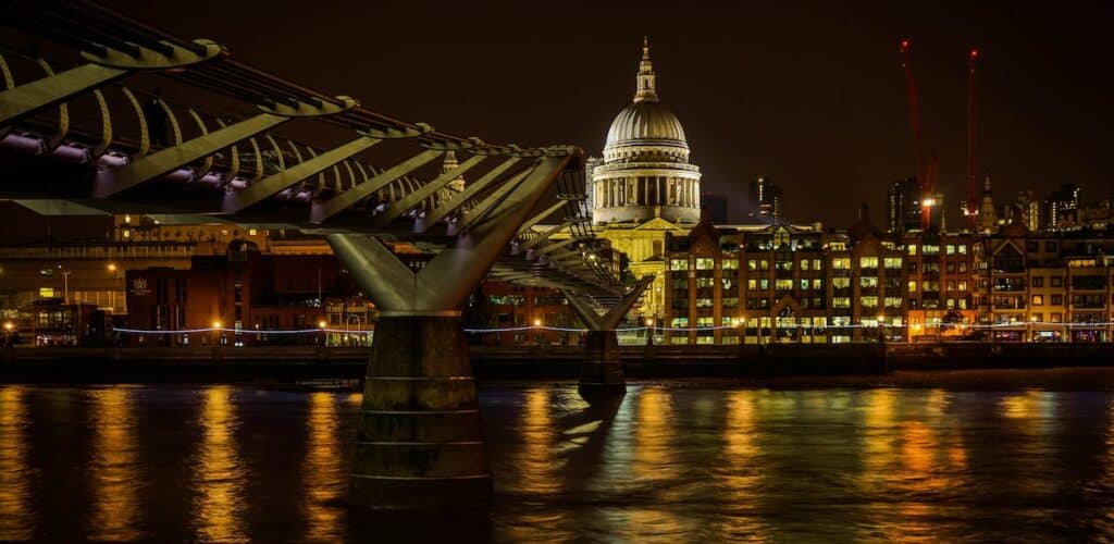 A view of the River Thames at night, lights reflecting off the water and St. Paul’s visible in the distance.
