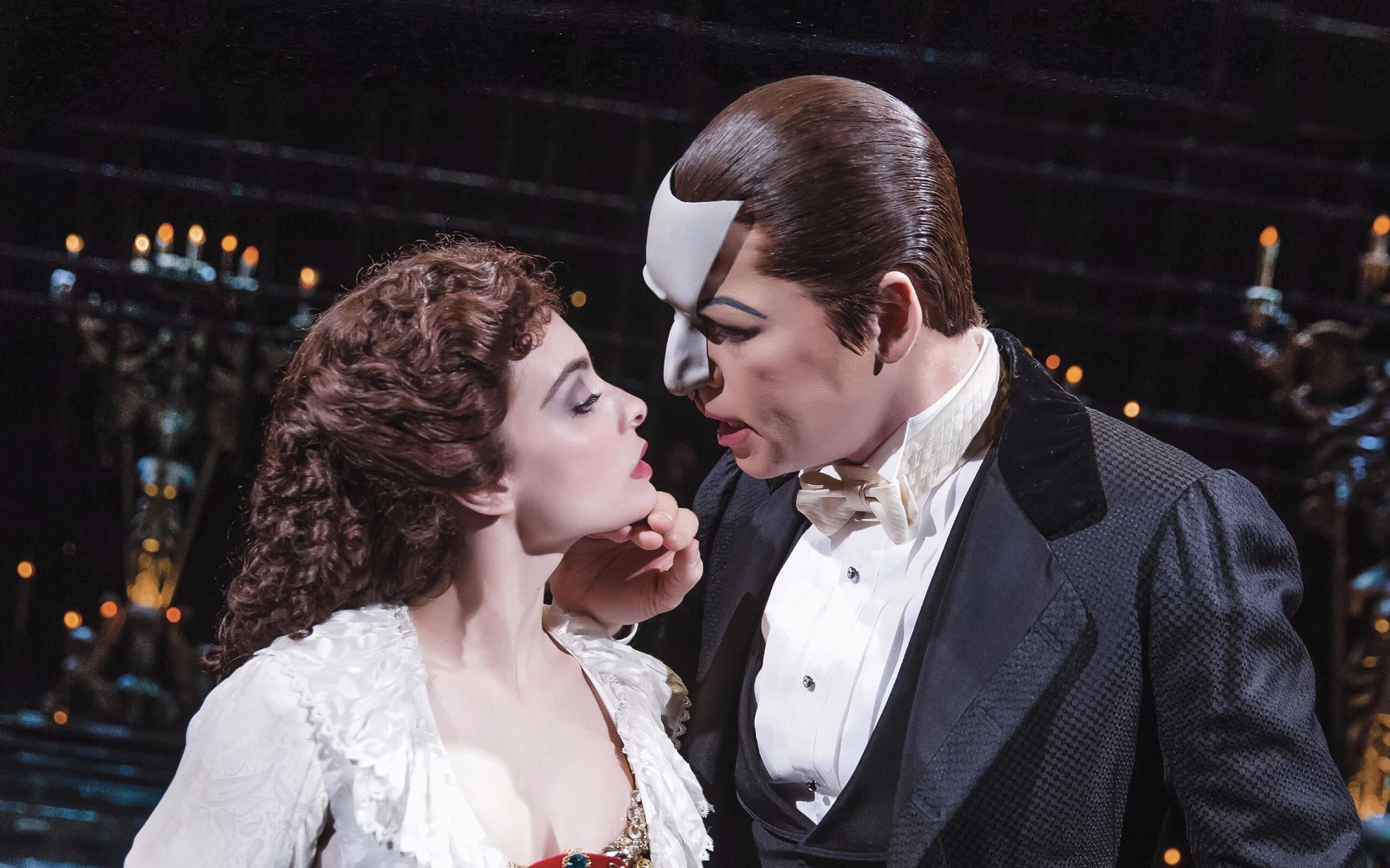 Publicity shot from Phantom of the Opera, the Phantom tipping Christine’s chin toward his face.