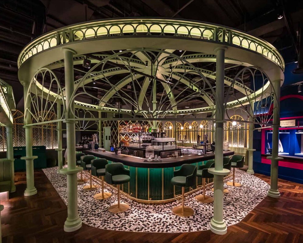 The Greenhouse Bar at Swingers NoMad, featuring a glass dome ceiling and a green-and-gold bar in the center.