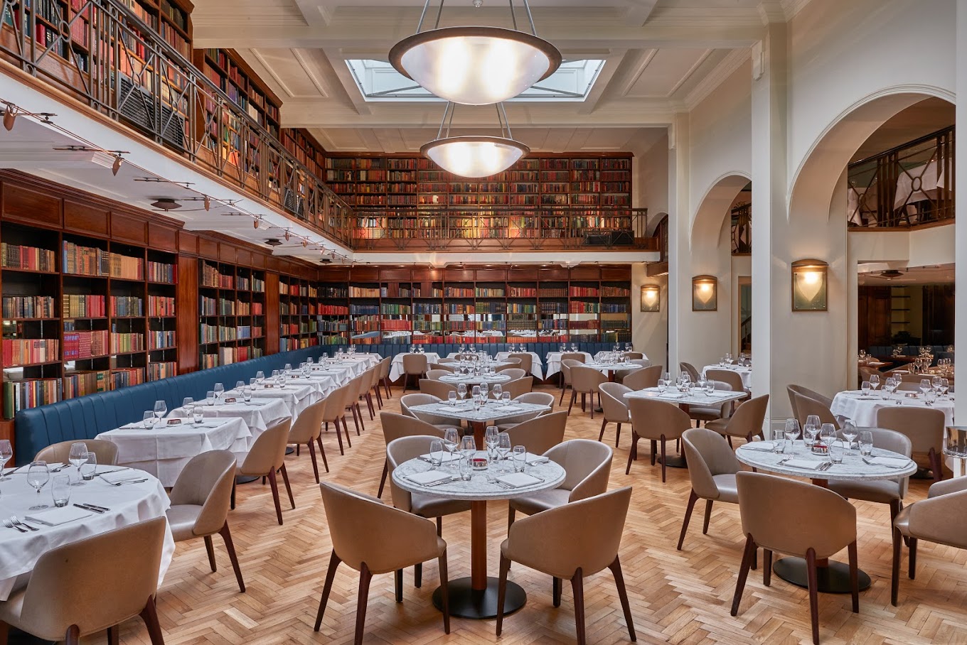 An upscale restaurant with multicoloured library shelves along the walls.