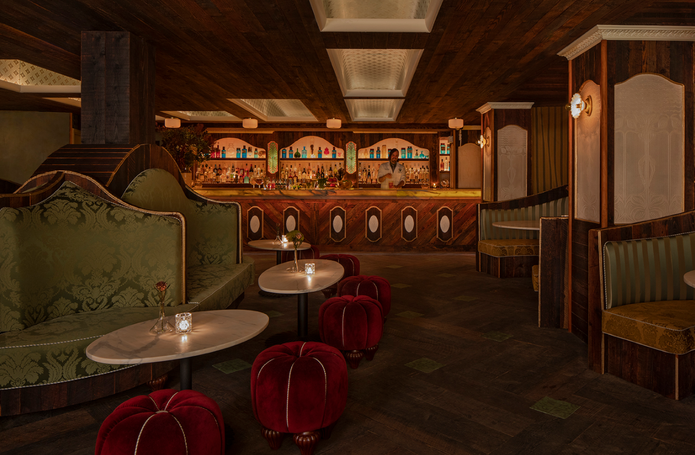 The low-lit interior of Apotheke, with olive green silk booths, red velvet stools and a Victorian-looking bar.