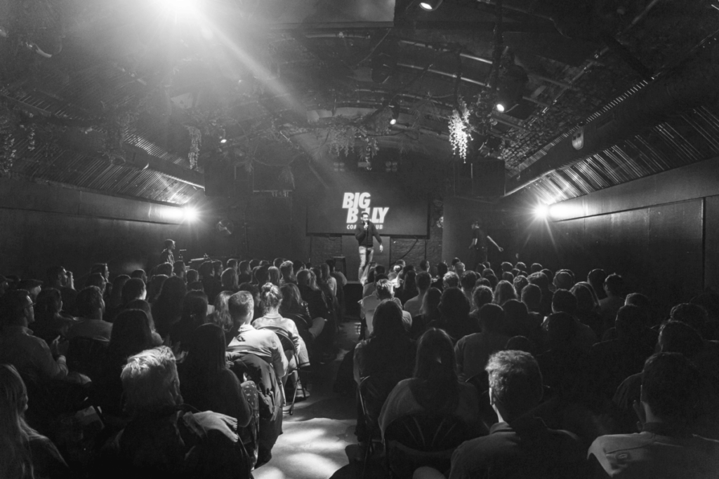 black and white image of crowd by a stage