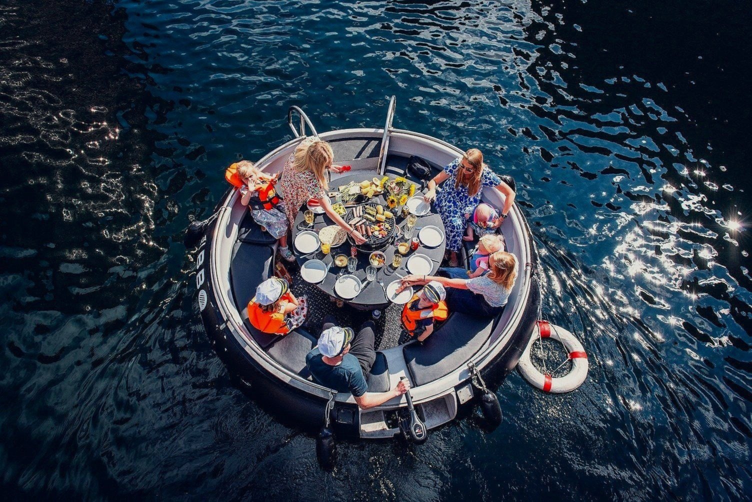 a grill boat on the river thames with nine people on it