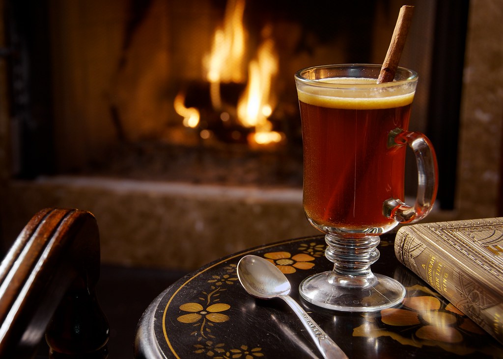  Hot Buttered Rum Cocktail with Cinnamon stick by the fire. 