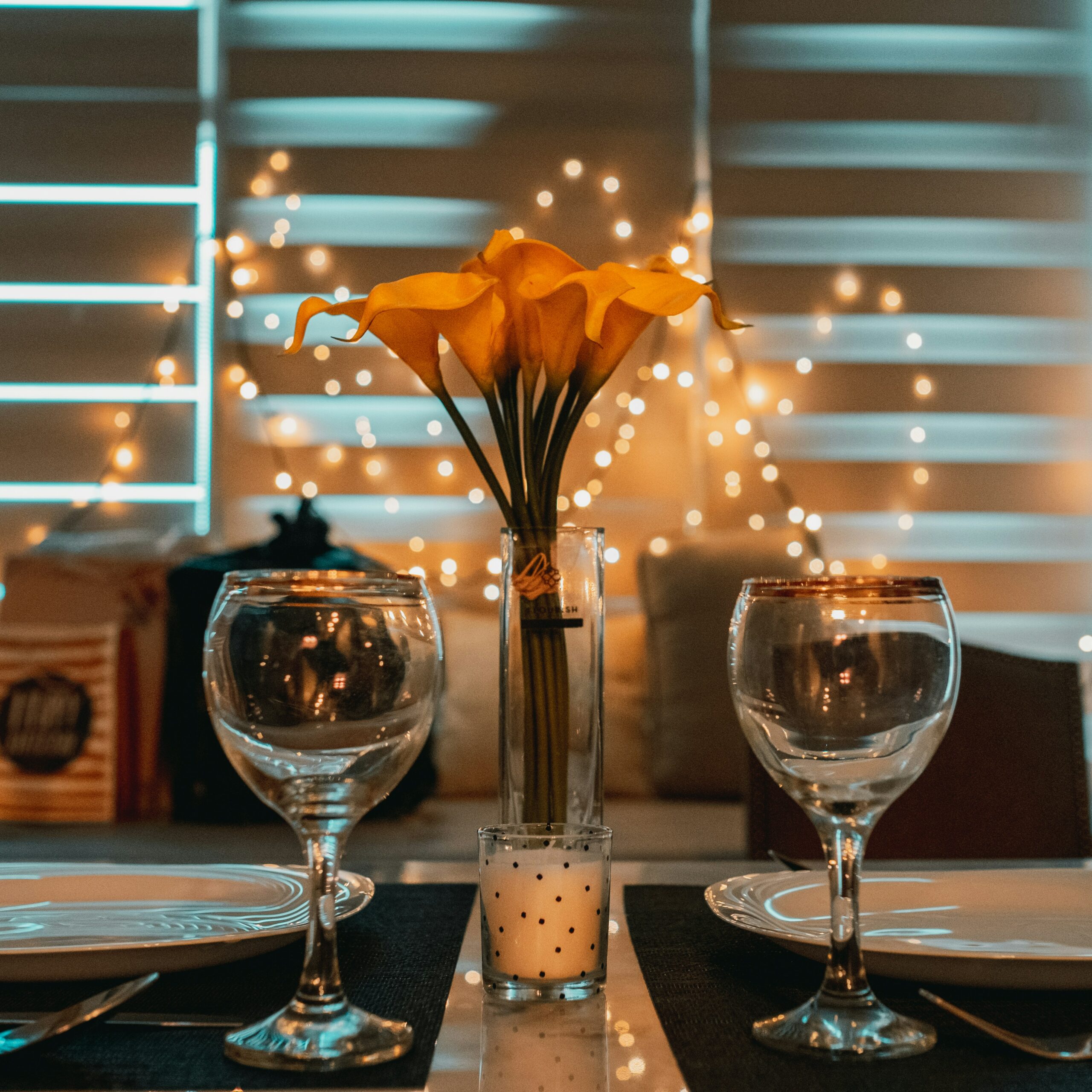 two wine glasses on a table with romantic background
